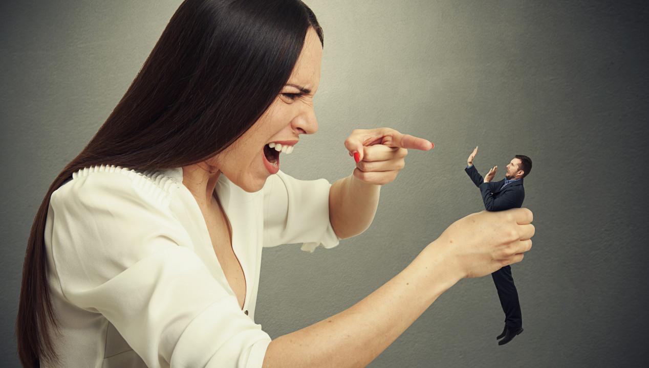 Businessfrau beschimpft einen erschrockenen Businessmann