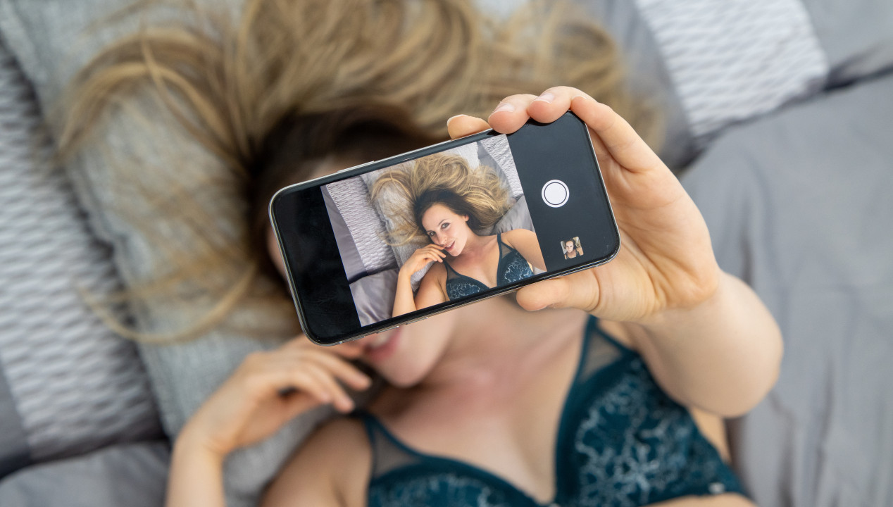 Sexy attraktive Frau liegt auf dem Bett Casual Dating Sexting Flirt