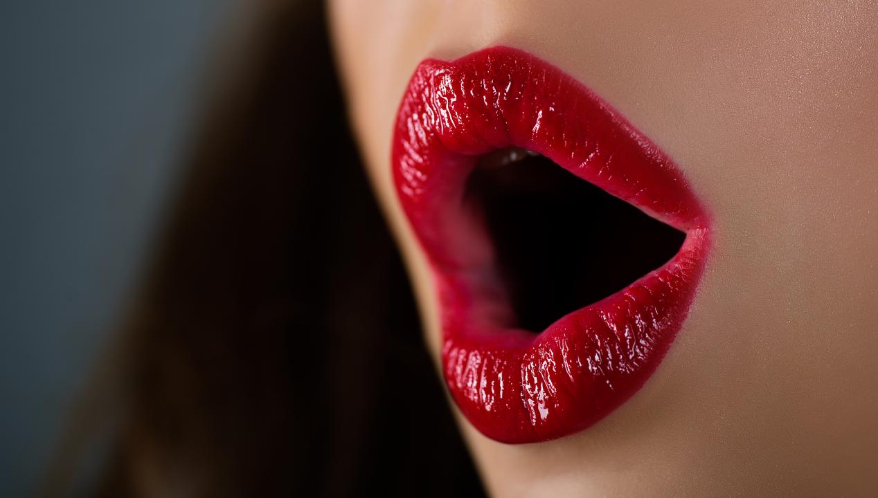 geöffnete, rot geschminkte Lippen einer Frau für einen Blowjob