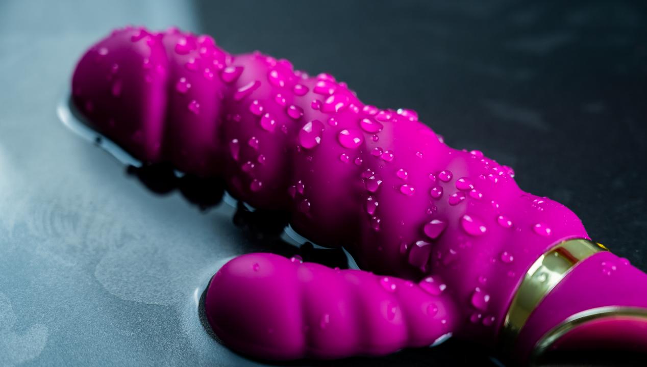 Reinigung und Pflege von Sextoys - pinker Vibrator liegt im Wasser