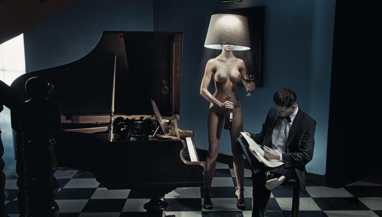 nackte Frau steht als Lampe verkleidet neben einem Mann an einem Klavier - Interpretation der "Geschichte der O"